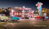 View of Miss Molly's Diner lite up with cars by it reminiscent of the 1950's