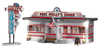 Old Fashion Diner called Miss Molly's Diner. American Flag flying outside by door. Trimmed in Red, Diner is white. Wooden sign with today's specials outside.